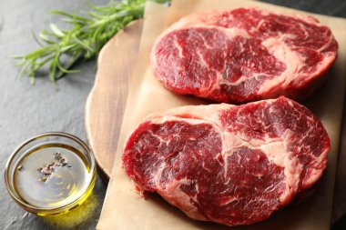 Siyah masanın üstünde çiğ et ve baharat parçaları.