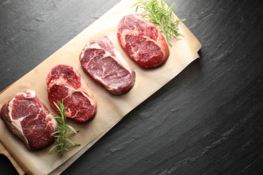 Çiğ et parçaları, biberiye ve siyah masaya tuz, üst manzara. Metin için boşluk