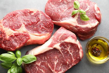 Çiğ et parçaları ve baharatlar gri masada, düz yatıyordu.