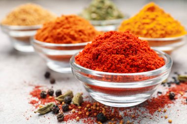 Açık gri masada farklı aromatik baharatlar, yakın plan.