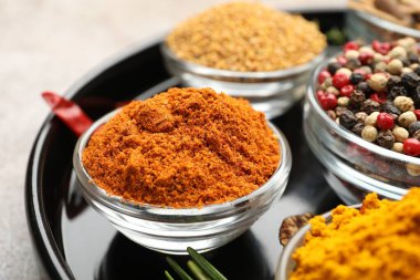 Açık gri masada farklı aromatik baharatlar, yakın plan.