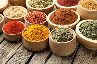 Tahta masadaki kaselerde farklı aromatik baharatlar, yakın plan.