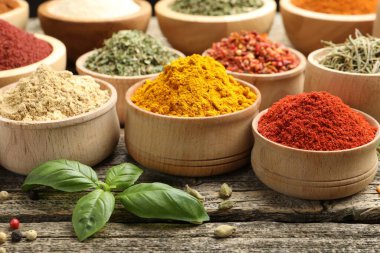 Ahşap masada farklı aromatik baharatlar, yakın plan.