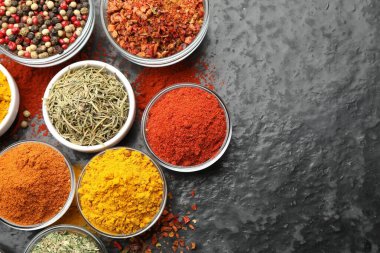 Tabaklardaki farklı aromatik baharatlar karanlık masada, düz yerde. Metin için boşluk