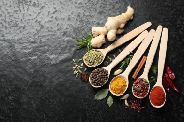 Siyah masadaki kaşıklarda bir sürü farklı baharat var. Metin için boşluk