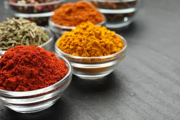 Gri masada farklı aromatik baharatlar, yakın plan.