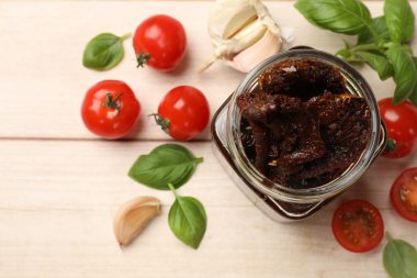 Lezzetli güneşte kurutulmuş domatesler, taze sebzeler, fesleğen ve sarımsak beyaz ahşap masa, düz uzanmış