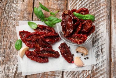 Lezzetli güneş, kurutulmuş domatesler ve baharatlar ahşap masada, düz yerde.