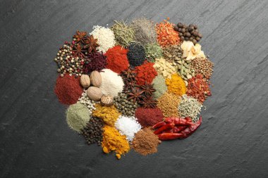 Gri masada farklı aromatik baharatlar, üst görünüm.