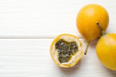 Olgun tutku meyveleri beyaz ahşap masada, düz yerde. Metin için boşluk