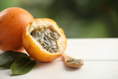 Olgun çarkıfelek meyveleri, yeşil yapraklar ve tohumlar açık havada, yakın plan. Metin için boşluk