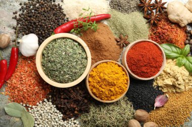 Gri masanın üzerinde bir sürü farklı baharat var.