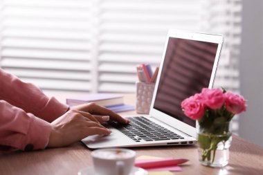 Ev ofisteki dizüstü bilgisayarda çalışan kadın, yakın plan.