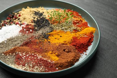 Koyu dokulu masada farklı aromatik baharatlar, yakın plan.