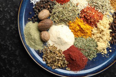 Koyu dokulu masa üzerinde farklı aromatik baharatlar, üst görünüm