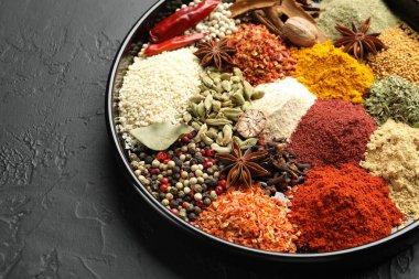 Koyu dokulu masada farklı aromatik baharatlar, yakın plan.