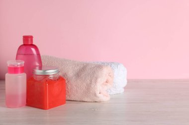 Farklı banyo aksesuarları açık ahşap masada pembe arka planda, yakın planda. Metin için boşluk