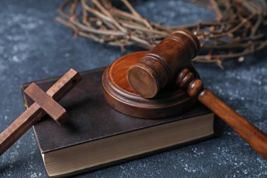 Dikenli taç, yargıç tokmağı, İncil ve ahşap haç, koyu dokulu arka plan, yakın çekim.