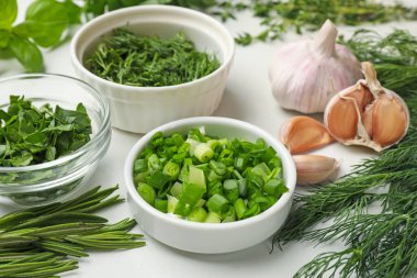 Beyaz masada farklı otlar ve baharatlar, yakın plan.