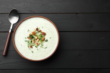Siyah ahşap masada servis edilen dereotlu ve cevizli leziz salatalık çorbası. Metin için boşluk