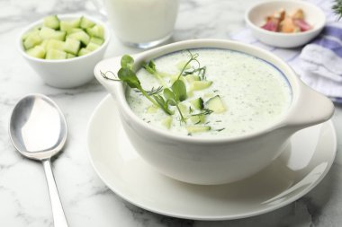 Beyaz mermer masada servis edilen dereotlu ve mikro yeşillikli lezzetli salatalık çorbası.