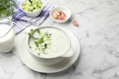 Dereotlu salatalık çorbası, mikro yeşiller ve beyaz mermer masa üzerindeki malzemeler, yakın plan.