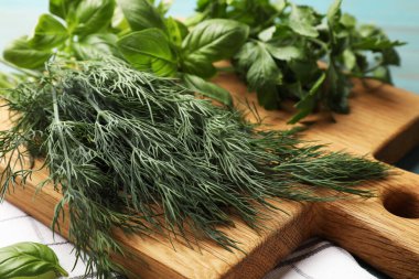 Mavi ahşap masada farklı taze otlar, yakın plan.