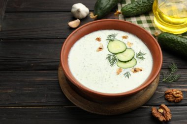 Dereotlu salatalık çorbası, ceviz ve ahşap masa malzemeleri, yakın plan.