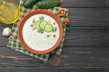 Dereotlu salatalık çorbası, ahşap masada ceviz ve malzemeler, düz yatak. Metin için boşluk