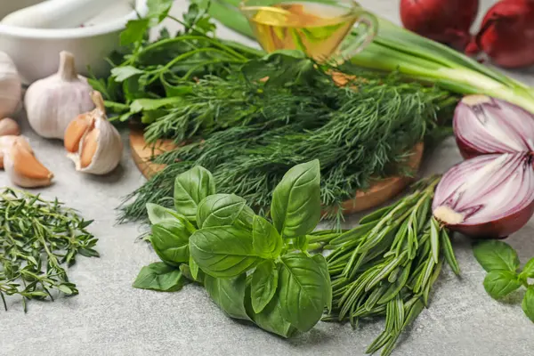 Gri masada farklı otlar ve baharatlar, yakın plan.