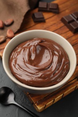 Kasede lezzetli puding, çikolata parçaları ve siyah masada kakao çekirdeği, yakın plan.