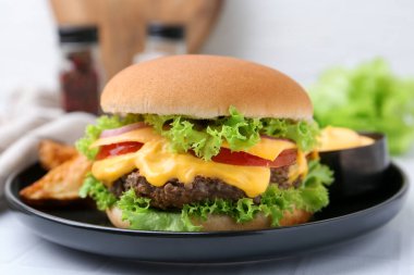 Beyaz masada soslu leziz bir çizburger, yakın plan.