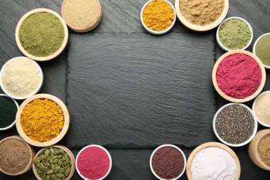 Siyah masadaki farklı süper yiyecek tozlarından oluşan bir çerçeve. Metin için boşluk