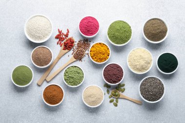 Açık gri masada farklı süper yiyecek tozları, düz yatıyordu.