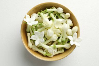 Güzel yasemin çiçekleri beyaz masada kasede, üst manzara