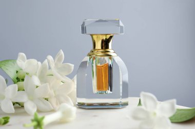 Parfüm ve yasemin çiçekleri gri arka planda, yakın plan