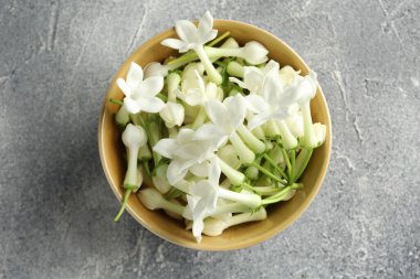 Güzel yasemin çiçekleri kasede Gri masada, üst manzara