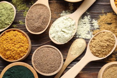 Tahta masanın üzerinde farklı süper yiyecek tozları var.