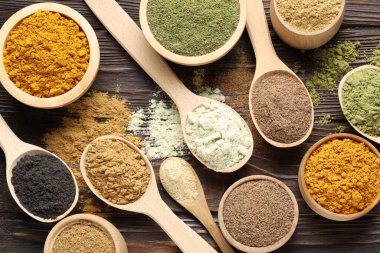 Tahta masanın üzerinde farklı süper yiyecek tozları var.