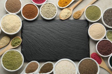 Farklı süper yiyecek tozları ve gri desenli masa, düz yatak tahtası. Metin için boşluk