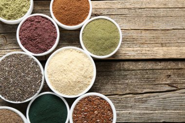 Tahta masadaki kaselerdeki farklı süper yiyecekler, düz yatış. Metin için boşluk