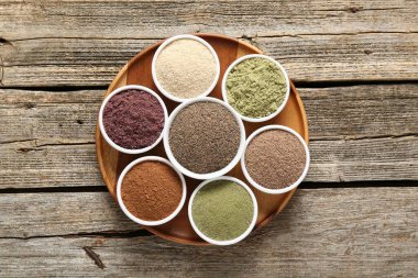 Tahta masadaki kaselerde farklı süper yiyecekler, üst manzara.