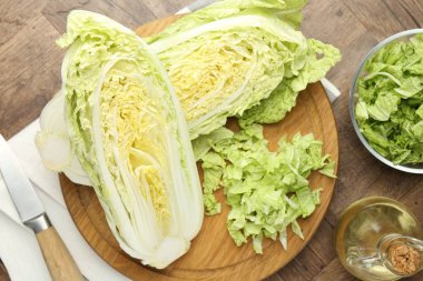 Taze kesilmiş Çin lahanası, yağ ve bıçak ahşap masada, düz yatıyordu.