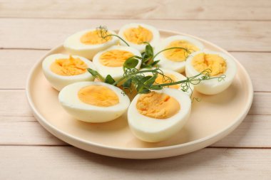 Haşlanmış yumurta ve mikroyeşiller ahşap masada, yakın plan.