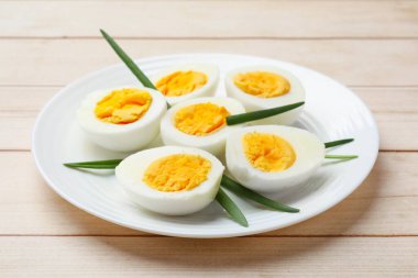 Haşlanmış yumurta ve yeşil soğan ahşap masada, yakın plan.