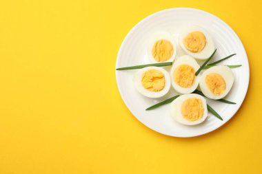 Sarı arka planda haşlanmış yumurta ve yeşil soğan. Metin için boşluk