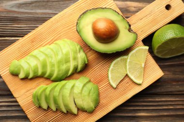 Olgun yeşil avokado ve kireç ahşap masada, düz yatıyordu.