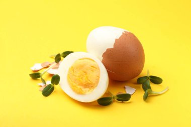 Sarı arka planda mikro yeşilli haşlanmış yumurta, yakın plan.