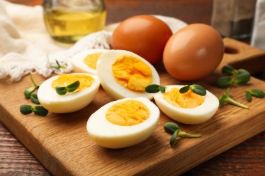 Tahta masanın üzerinde mikro yeşillikli haşlanmış yumurtalar, yakın plan.