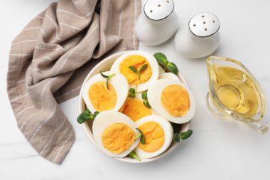 Beyaz masa üzerinde mikro yeşillik ve haşlanmış yumurtalardan oluşan yarımlar.